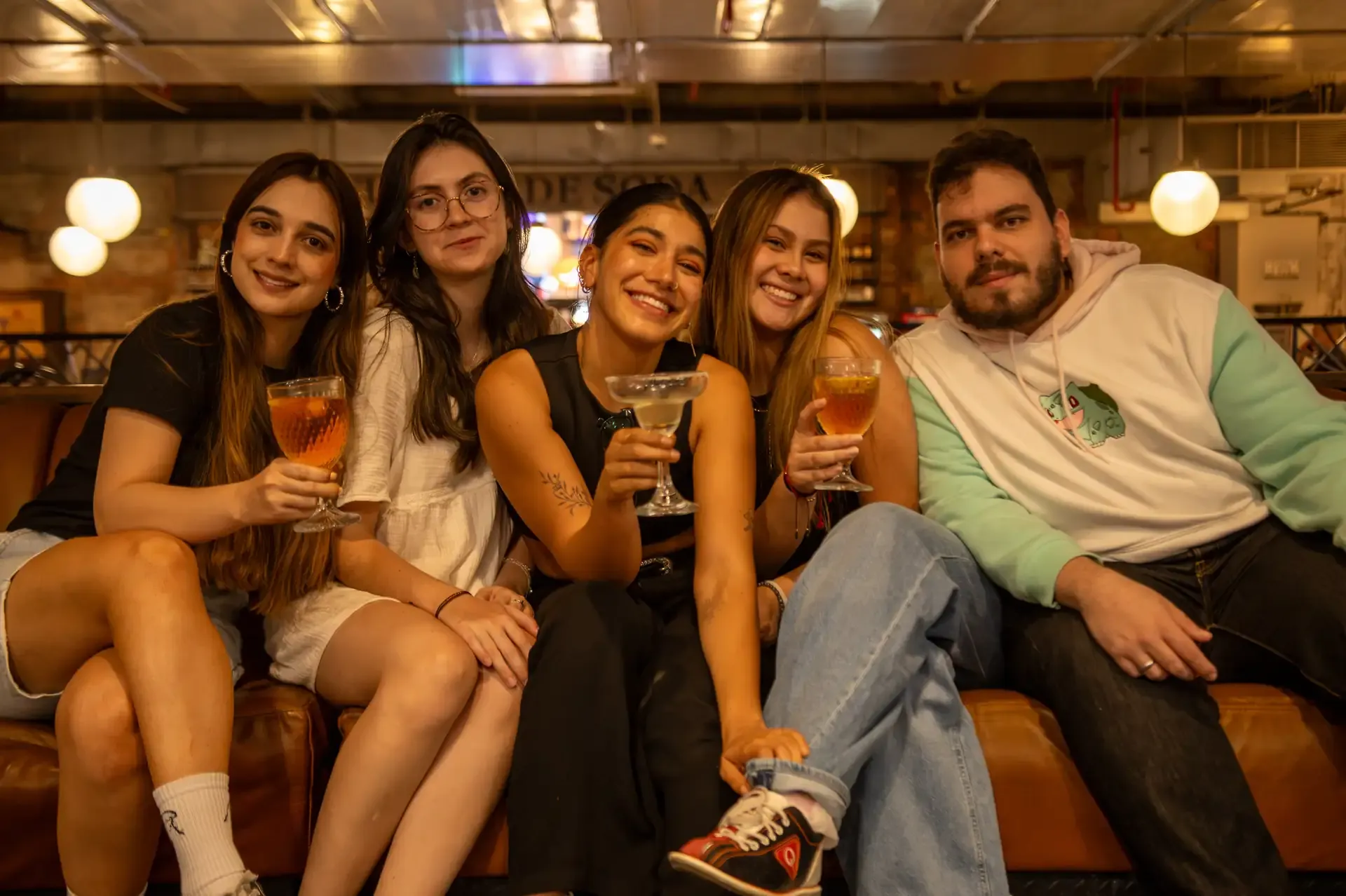 Amigos conversan en el sofá del restaurante de la bolera